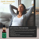 Woman relaxing on a couch with Earth Essentials Stress Away Blend oil bottle displayed.